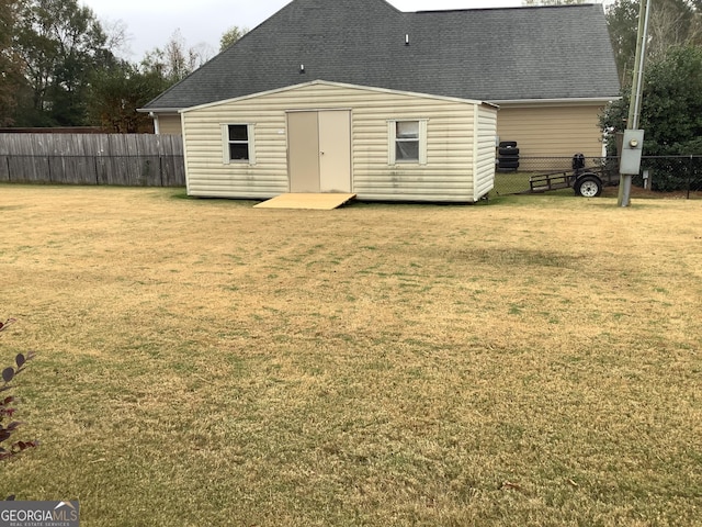 rear view of house with an outdoor structure and a lawn