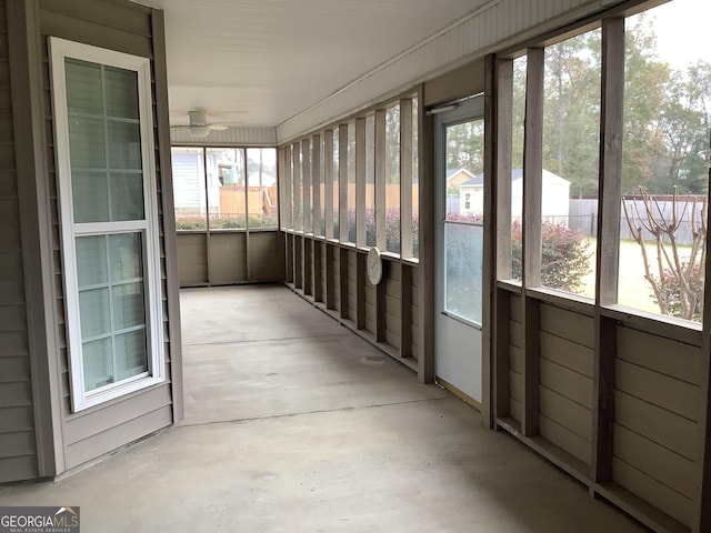 unfurnished sunroom featuring ceiling fan