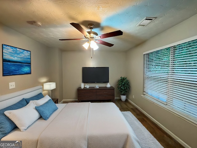 bedroom with ceiling fan and dark wood-type flooring