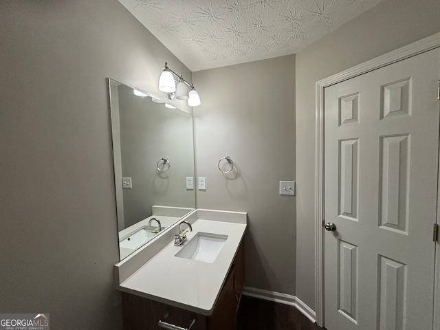 bathroom featuring a textured ceiling and vanity