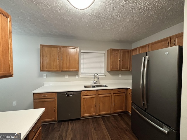 kitchen with sink, a textured ceiling, black dishwasher, stainless steel fridge, and dark hardwood / wood-style flooring