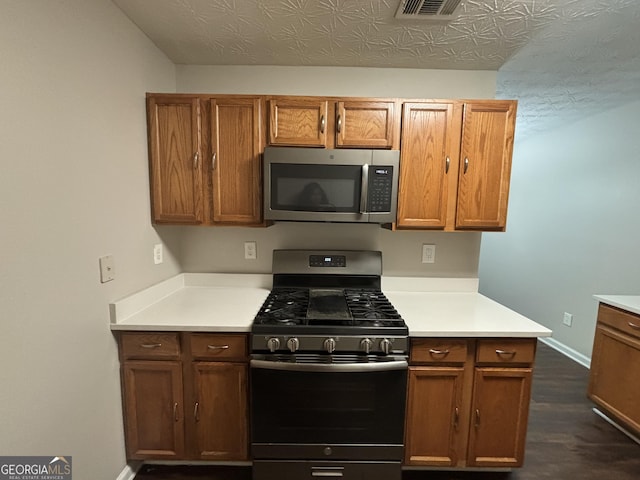 kitchen with stainless steel appliances and dark hardwood / wood-style floors