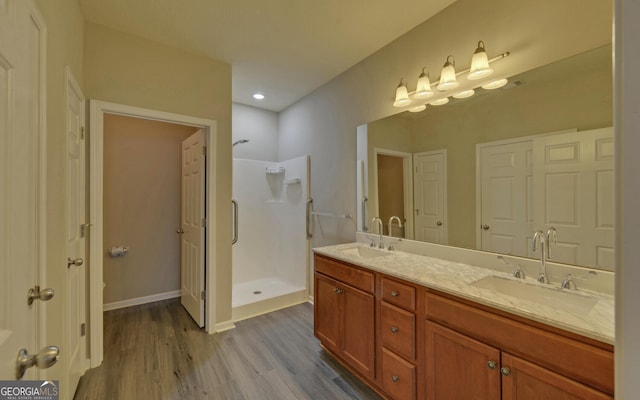 bathroom with a shower, vanity, and hardwood / wood-style floors