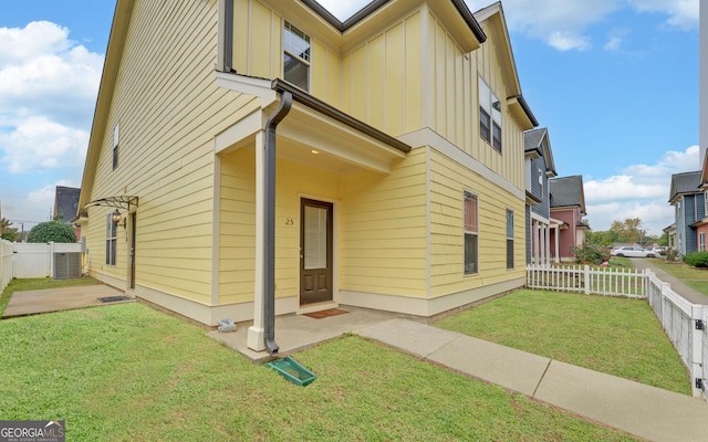 exterior space with central AC unit and a front lawn