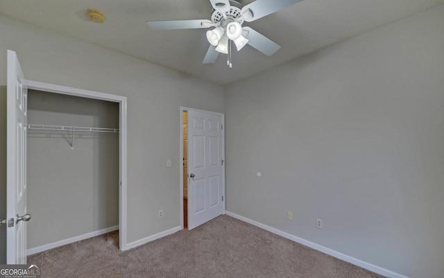 unfurnished bedroom with a closet, light colored carpet, and ceiling fan