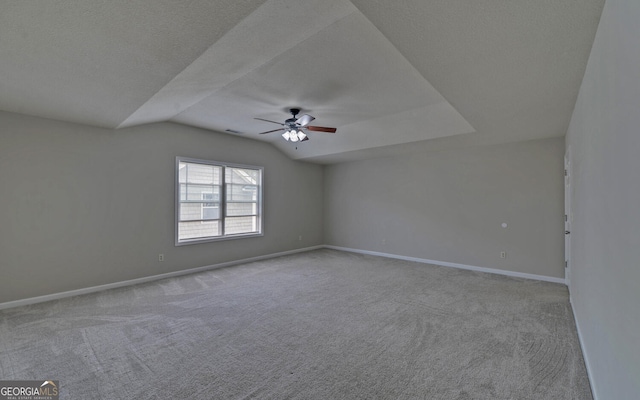 carpeted empty room featuring a textured ceiling, ceiling fan, and vaulted ceiling