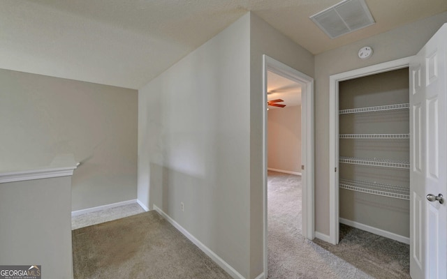 hallway featuring light colored carpet