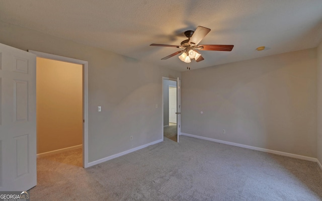 carpeted spare room with a textured ceiling and ceiling fan