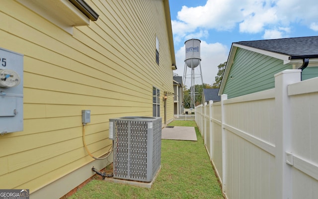 view of side of home with cooling unit and a lawn