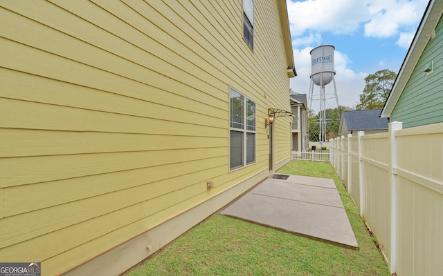 view of property exterior with a yard and a patio