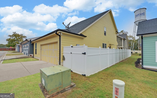 view of side of home featuring a garage and a yard