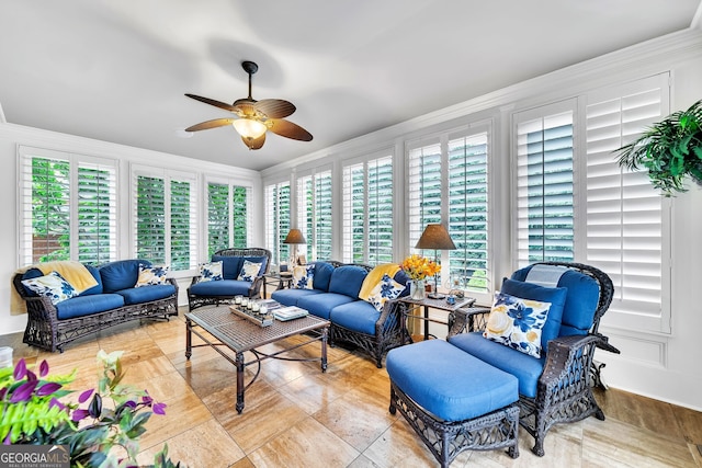 living room with ornamental molding and ceiling fan