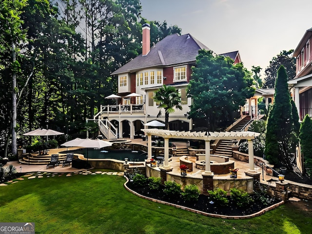 rear view of house featuring a lawn, a pergola, a fire pit, and a patio area