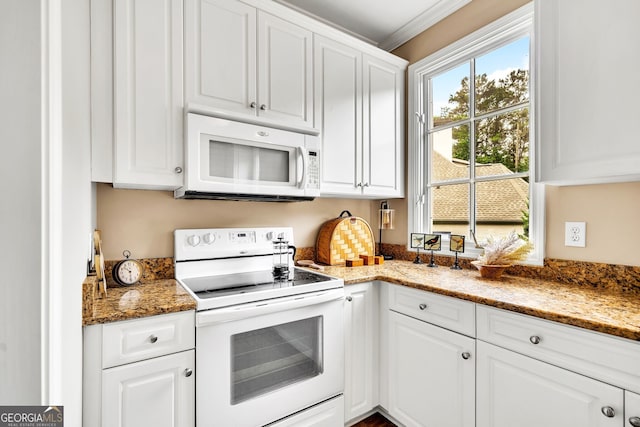 kitchen with dark stone countertops, white appliances, crown molding, and white cabinets