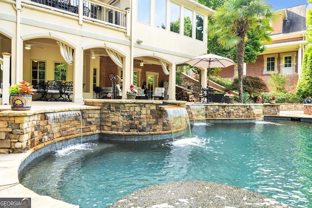 view of swimming pool with a jacuzzi, pool water feature, and a patio area