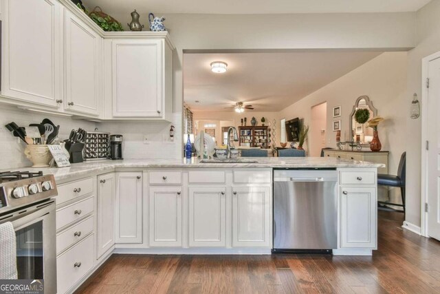 kitchen with tasteful backsplash, stainless steel appliances, dark wood-type flooring, sink, and white cabinetry