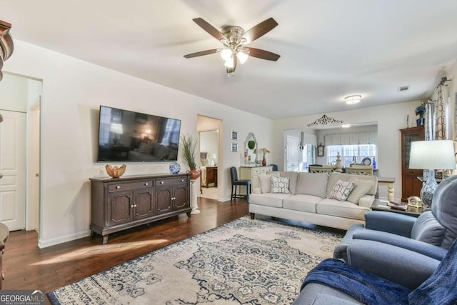 living room featuring ceiling fan and dark hardwood / wood-style flooring