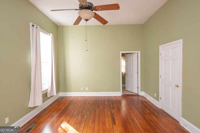 empty room with ceiling fan and dark hardwood / wood-style flooring