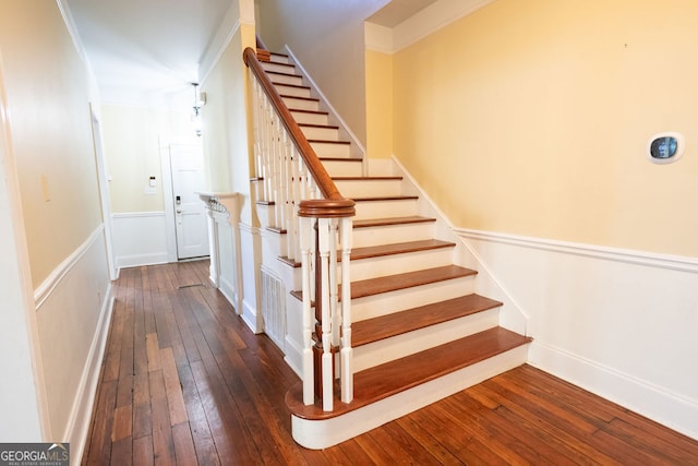 stairs with ornamental molding and hardwood / wood-style flooring