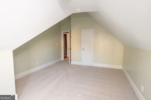 bonus room with light carpet and vaulted ceiling