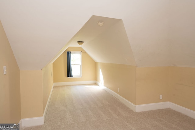 bonus room with light carpet and vaulted ceiling