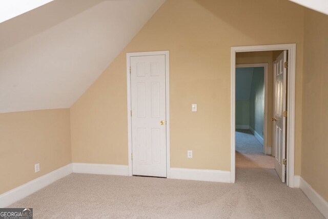 bonus room featuring vaulted ceiling and light carpet