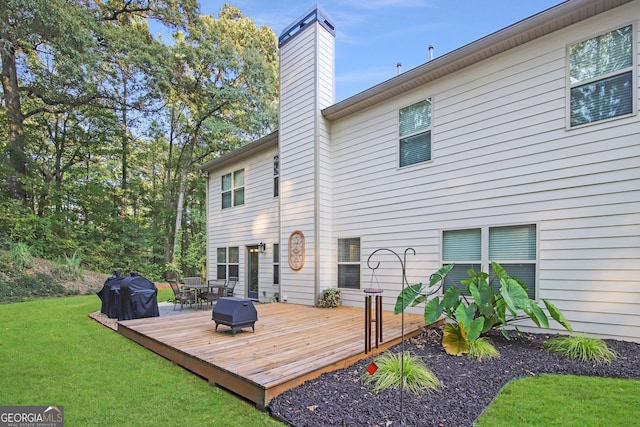 back of house featuring a lawn and a wooden deck