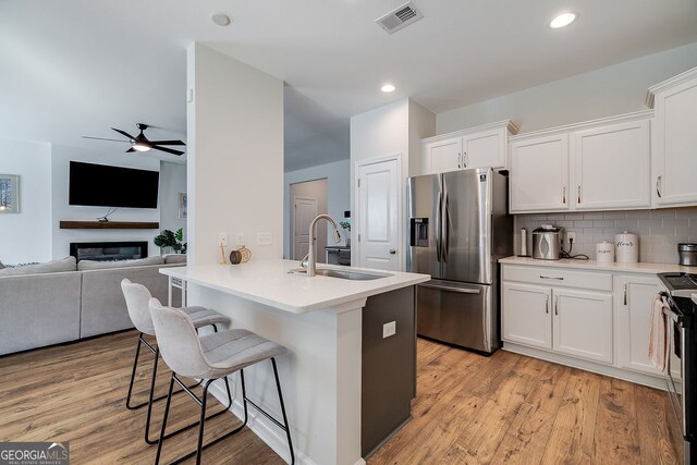 kitchen featuring white cabinetry, appliances with stainless steel finishes, sink, and a breakfast bar