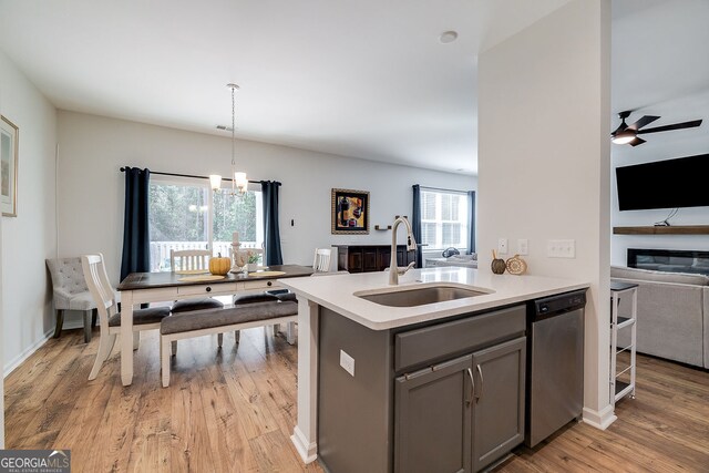 kitchen featuring dishwasher, plenty of natural light, sink, and decorative light fixtures