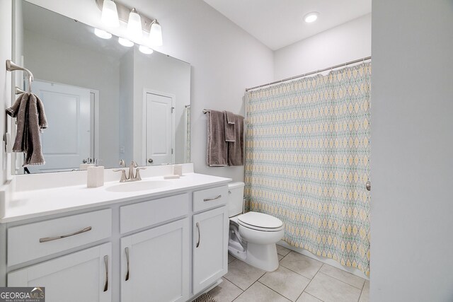 bathroom with toilet, vanity, tile patterned flooring, and walk in shower