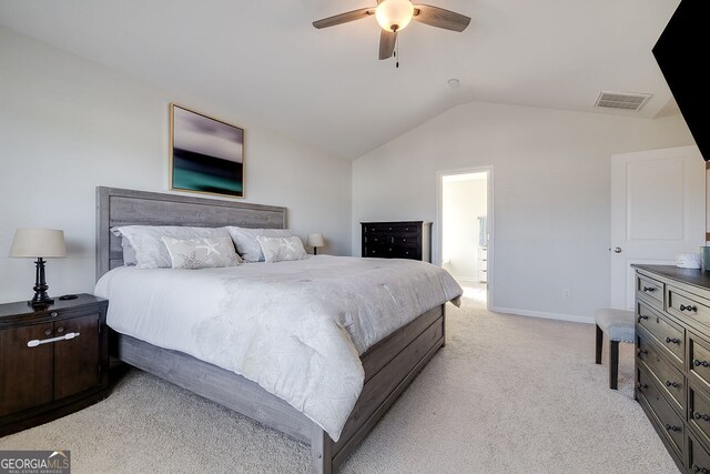 bedroom with ensuite bathroom, light colored carpet, lofted ceiling, and ceiling fan