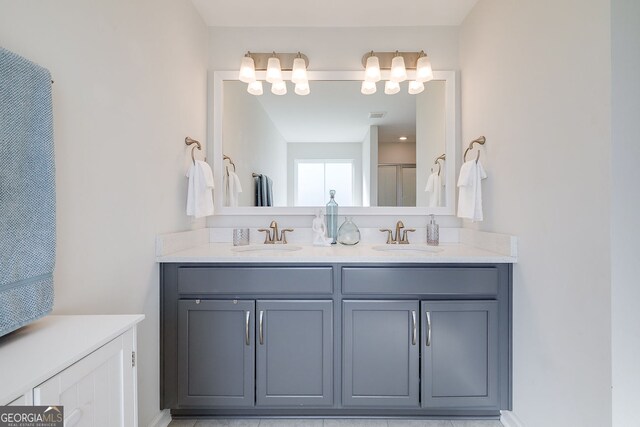 bathroom with walk in shower, vanity, and tile patterned floors