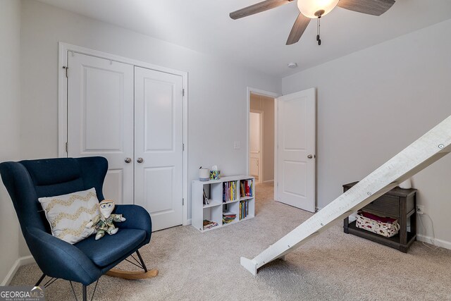 sitting room with ceiling fan and light carpet