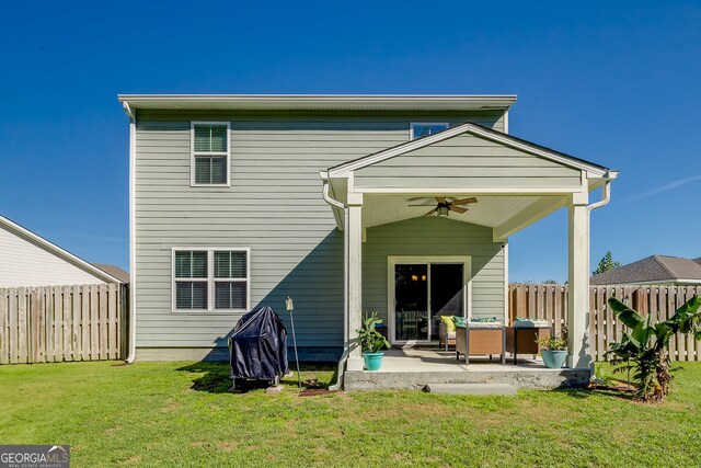 rear view of house featuring ceiling fan, a yard, and a patio