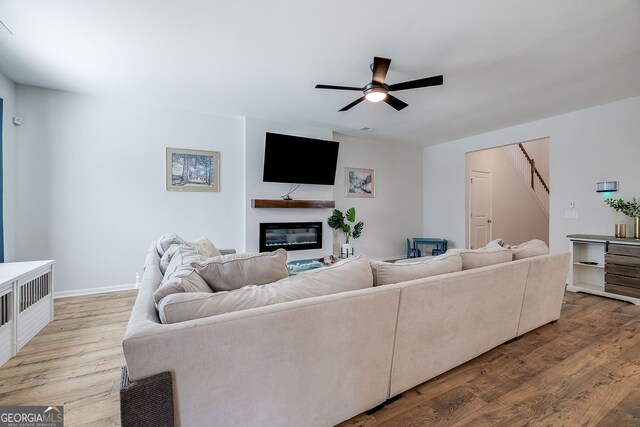 living room featuring ceiling fan and light hardwood / wood-style flooring