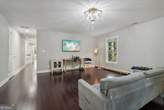 living area with baseboards, attic access, visible vents, and wood finished floors