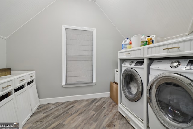 clothes washing area with wood-type flooring and independent washer and dryer