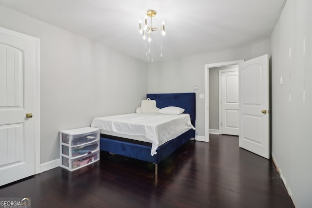 bedroom with dark hardwood / wood-style flooring and a notable chandelier