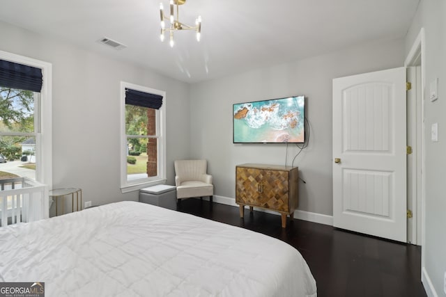 bedroom featuring a chandelier and dark hardwood / wood-style flooring