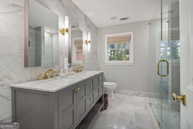 full bath featuring visible vents, a sink, a shower stall, and double vanity