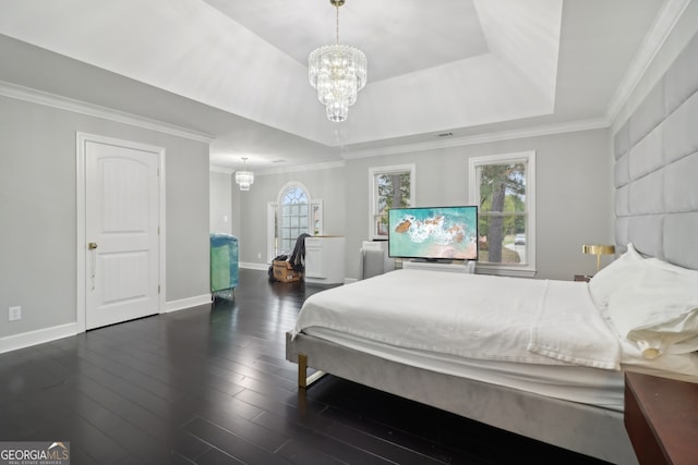 bedroom with a notable chandelier, wood finished floors, baseboards, a raised ceiling, and crown molding