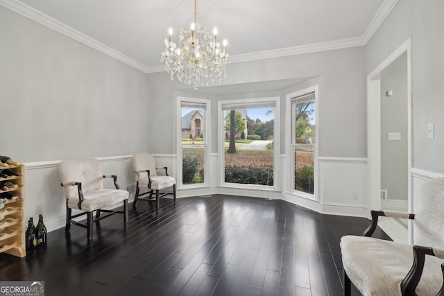 sitting room with dark wood-type flooring, an inviting chandelier, and crown molding