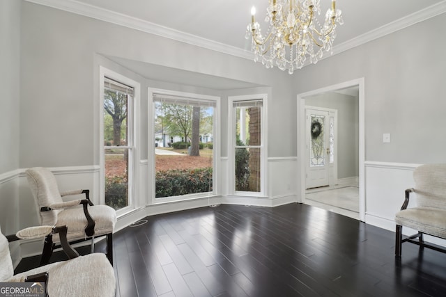 living area featuring hardwood / wood-style flooring, a chandelier, and crown molding