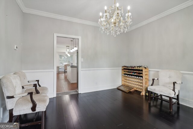 living area with ornamental molding, dark hardwood / wood-style flooring, and a notable chandelier