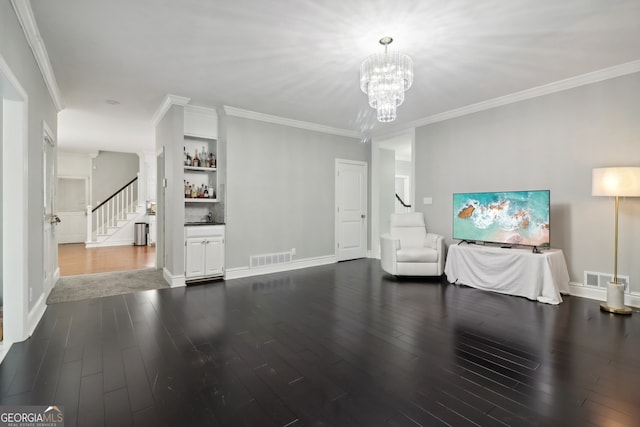 unfurnished living room with dark hardwood / wood-style floors, crown molding, and an inviting chandelier