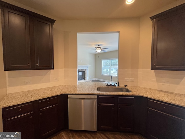 kitchen featuring stainless steel dishwasher, dark brown cabinetry, dark hardwood / wood-style flooring, and sink