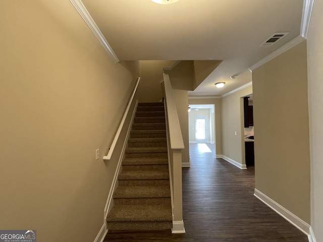 stairway featuring wood-type flooring, ceiling fan, and crown molding