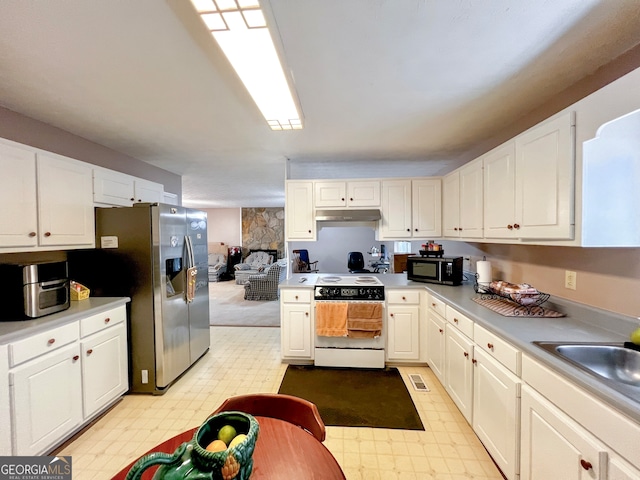 kitchen with white cabinets, stainless steel refrigerator with ice dispenser, white range, and sink