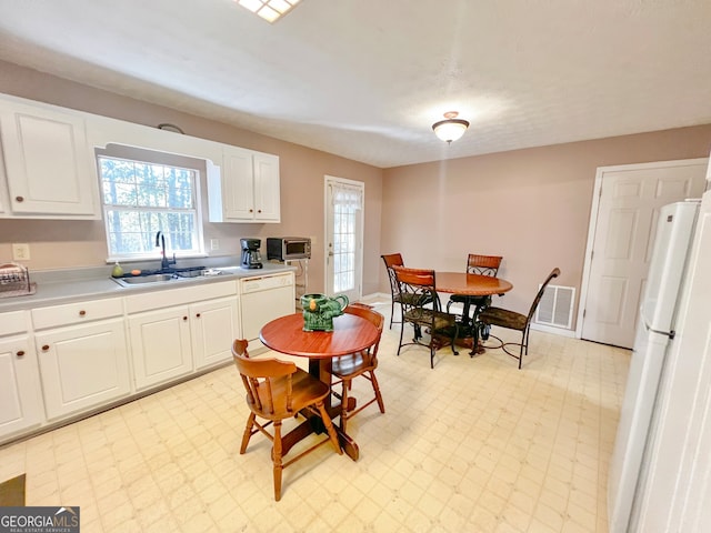 kitchen featuring white appliances, white cabinetry, and sink