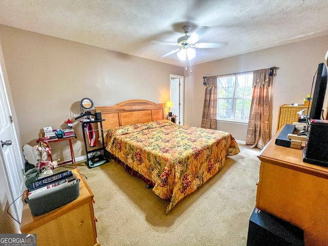 carpeted bedroom featuring a textured ceiling and ceiling fan